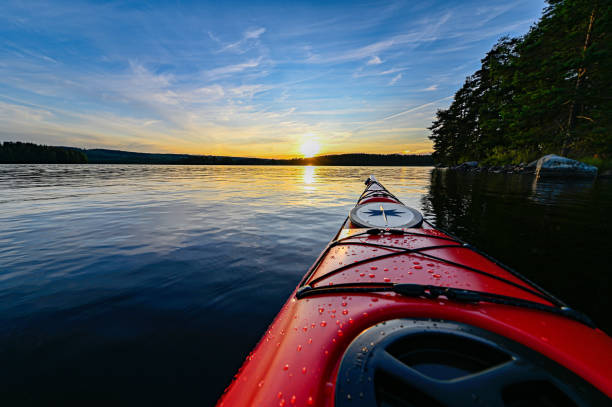 夕日の穏やかな水に赤いプラスチックカヤック - kayaking kayak sea coastline ストックフォトと画像