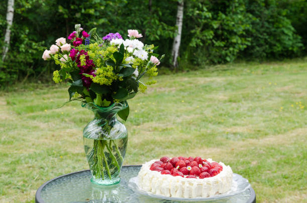 istock Summer flowers and a strawberry cake on a table 1165839294
