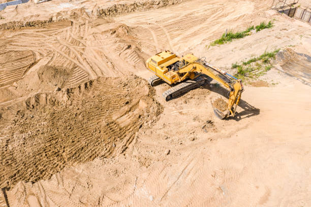 istock aerial top view of yellow excavator at construction site 1165841410