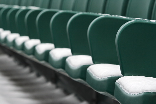 Stadium seating with light snow cover, in diminishing perspective with foreground focus.