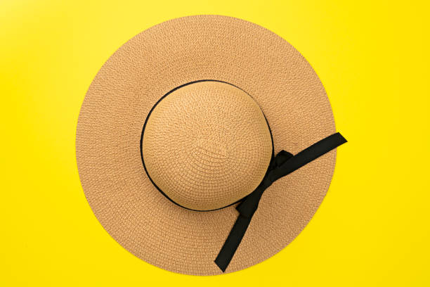Top view straw hat with ribbon and bow on pastel yellow background. Beach accessory. Fashion  summer concept. Flat lay Top view straw hat with ribbon and bow on pastel yellow background. Beach accessory. Fashion  summer concept. Flat lay. sun hat stock pictures, royalty-free photos & images