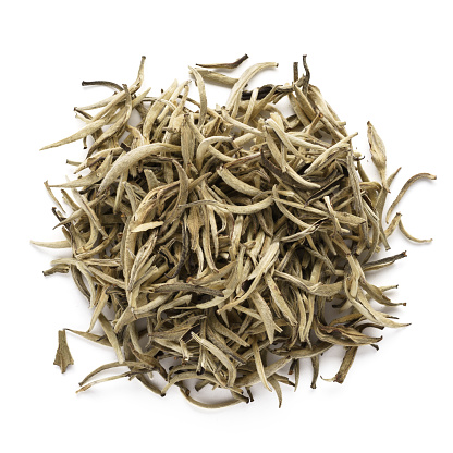 Dry white tea leaves isolated on white background. Heap of Chinese Bai Hao Yin Zhen tea. Top view.