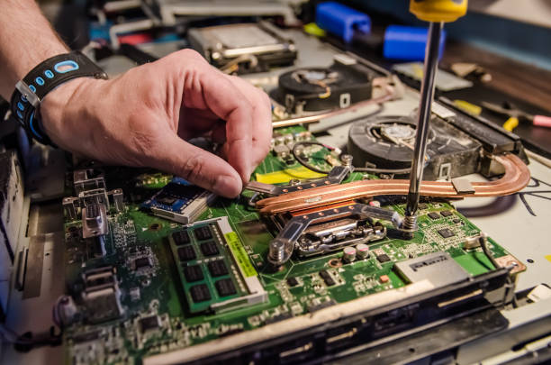 istock Technical support worker unspins the cover of the computer monoblock with a screwdriver 1165853229