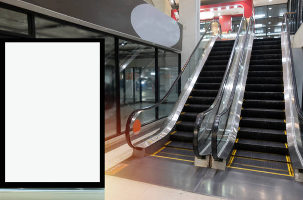 istock blank showcase billboard or advertising light box for your text message or media content in front of escalator in modern department store shopping mall, commercial and marketing concept 1165857997