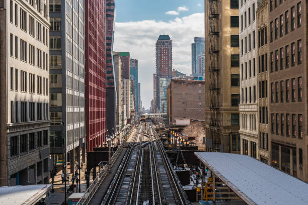 Elevated Train Tracks are running above the Railroad tracks between the building at the Loop line at Chicago, Illinois, USA