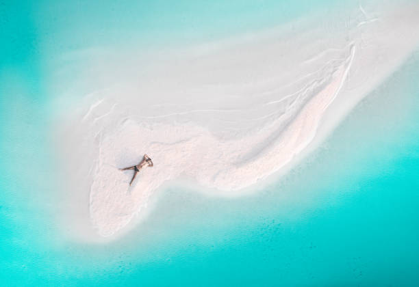 a man sunbathes on a small uninhabited island. aerial shot. - men sensuality photography high angle view imagens e fotografias de stock