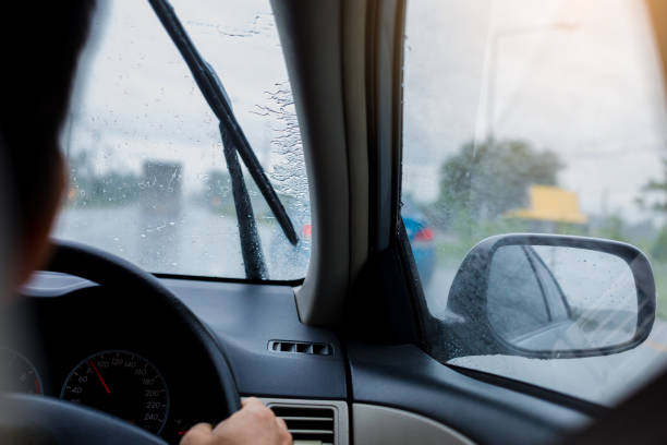 istock Selective focus to man driving a car with rain droplet on windshield and wiper. 1165879724