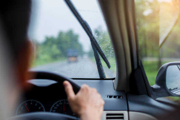 istock Selective focus to man driving a car with rain droplet on windshield and wiper. 1165879745