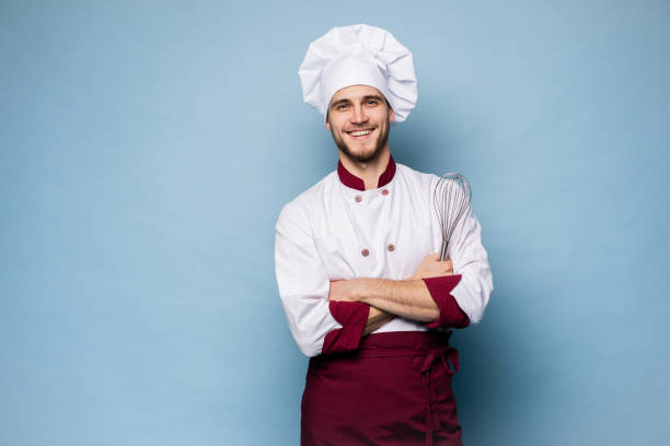 istock Portrait of smiling chef on light blue background 1165879748