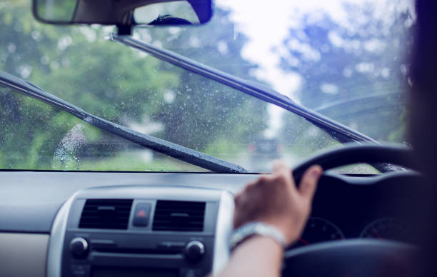 istock Selective focus to man driving a car with rain droplet on windshield and wiper. 1165880257