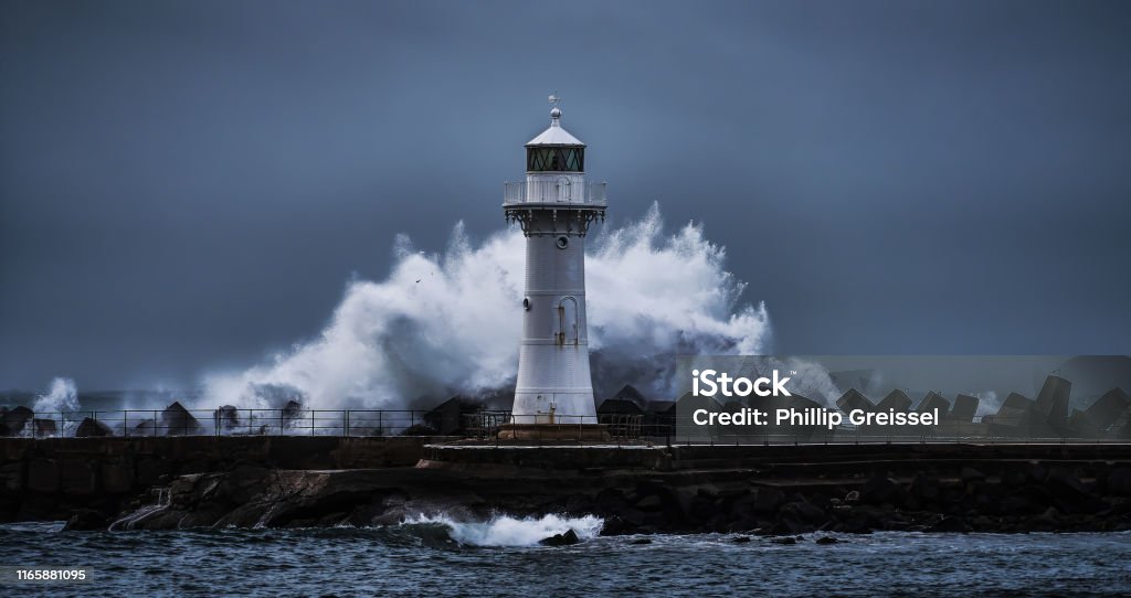 Wollongong Breakwater Lighthouse during a heavy storm Wollongong Harbour, NSW, Australia - June 4: Wave breaking in a circular way behind the Breakwater Lighthouse of Wollongong during a storm, 16:9 aspect ratio Lighthouse Stock Photo