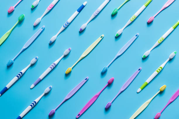 vista superior das escovas de dente no colorido no fundo pastel da cor. - toothbrush plastic multi colored hygiene - fotografias e filmes do acervo