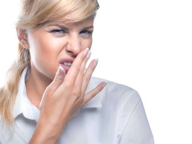 Disgust and bad smell. Woman covering her mouth by hand stock photo