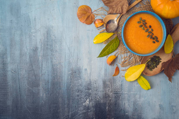 istock Pumpkin soup on rustic background. Autumn concept with pumpkin and fall leaves. 1165890664