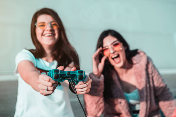 istock Two female young friends playing video games with controller 1165891019