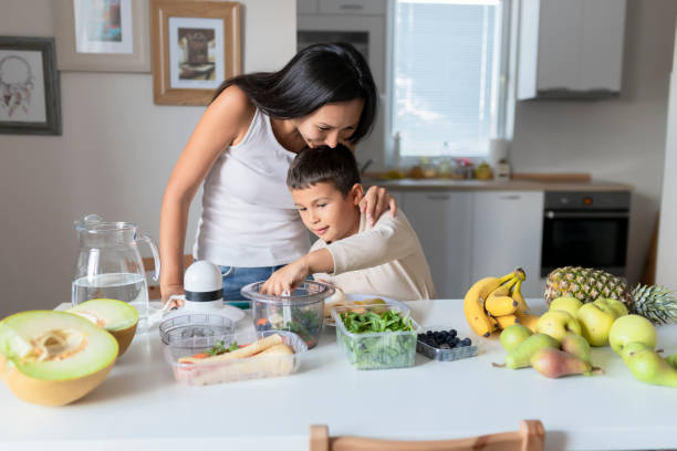 istock Mother and Little Son Blending Smoothie in Kitchen 1165898438