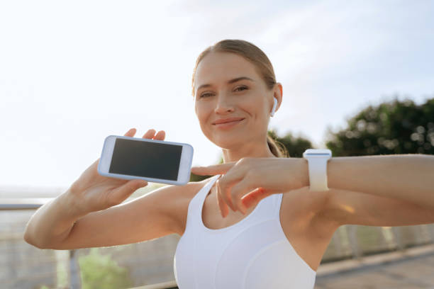 istock Happy athletic female point on mobile phone 1165900568