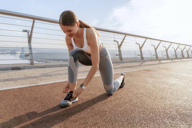 istock Sportive young lady tie shoelaces before running 1165900593