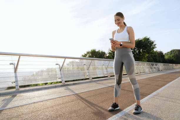 istock Happy athletic lady with mobile phone on training 1165900595