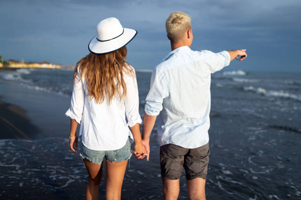 istock Happy young couple having fun and love on the beach 1165901725