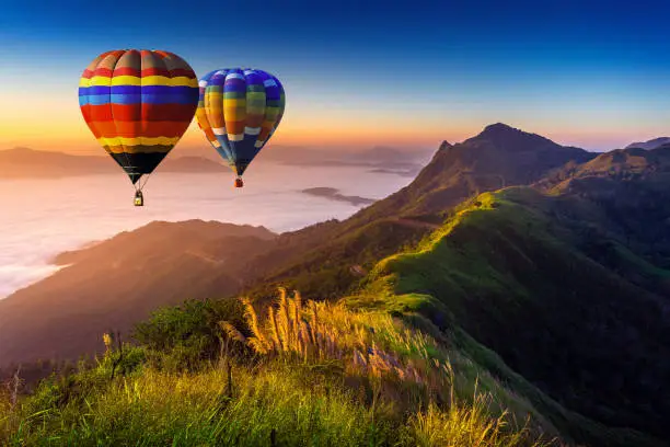 Photo of Landscape of morning fog and mountains with hot air balloons at sunrise.