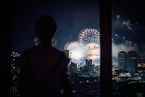 Women see the fireworks from the window of the apartment
