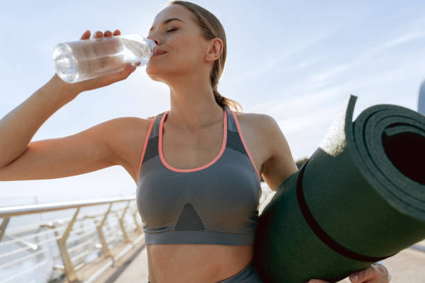 istock Sportive lady drinking clean water after training 1165904534