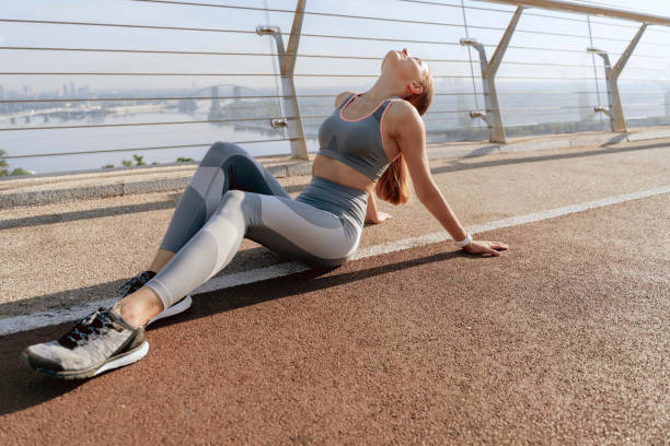 istock Sportive young lady resting on ground of bridge 1165904605
