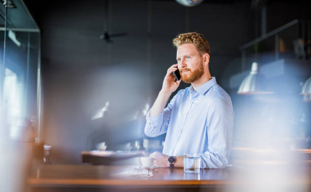 istock Young businessman having a phone call while in a coffee shop. 1165905489