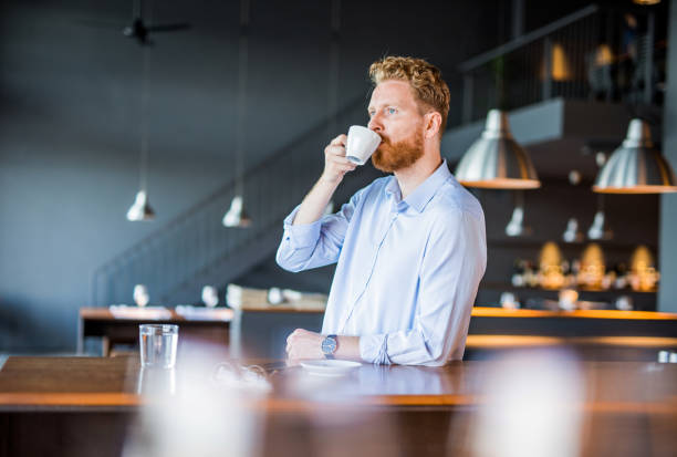 istock Young man drinking coffee on a break in coffee shop. 1165905520