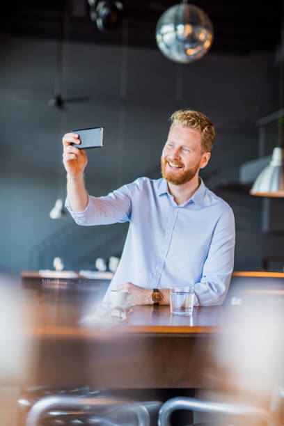 istock Happy young man taking a selfie in a coffee shop. 1165905564