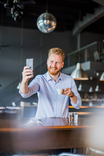 istock Happy young man taking a selfie in a coffee shop. 1165906486
