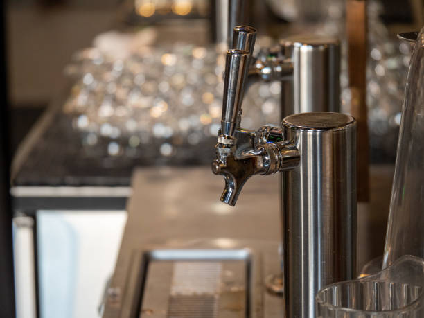 istock Silver beer taps behind bar counter tap next to clean glasses 1165906744