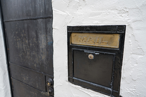 Black mail slot and lock outside of door of a building