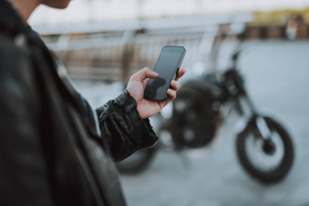 istock Hand of young biker holding modern smartphone 1165908232