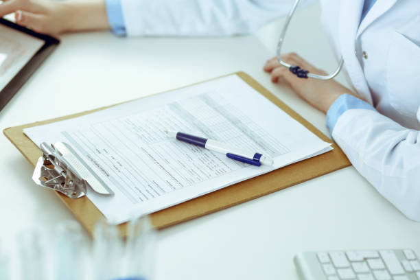 istock Doctor working table. Woman physician using tablet computer while sitting in hospital office close-up. Healthcare, insurance and medicine concept 1165910621