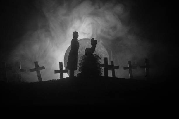 istock Halloween. Scary zombie bride on a night cemetery holds a pumpkin lantern. 1165911870