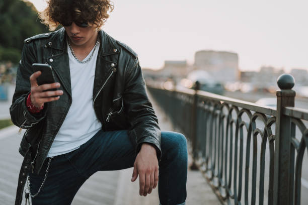 istock Curly serious man looking at the screen of gadget 1165913570