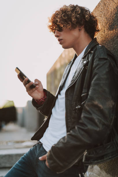istock Young man near the wall with smartphone 1165913662