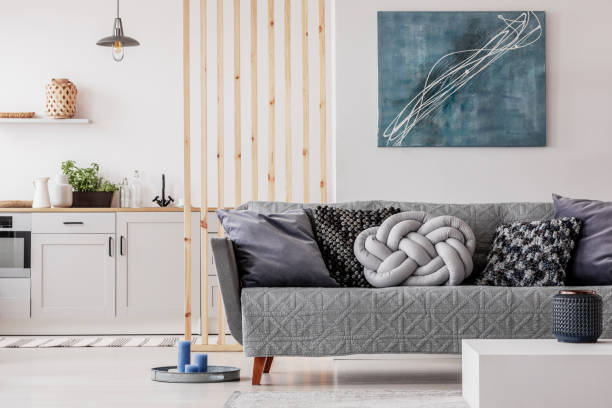istock Trendy knot light grey pillow on comfortable scandinavian couch 1165916818