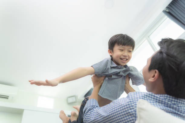 istock Happy son playing with father while ride dad back and dad lying on the bed at home 1165917562