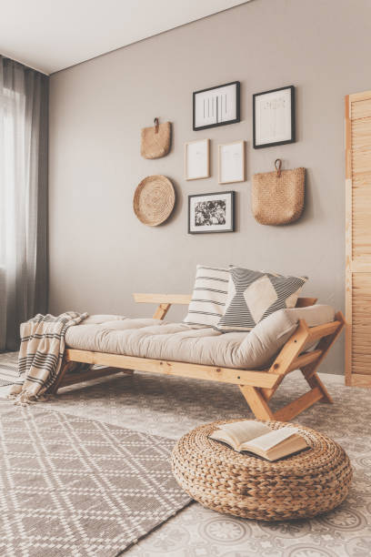 istock Open book on wicker pouf in bright living room interior 1165918883