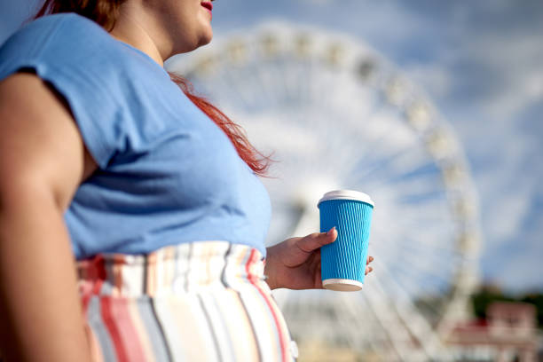 istock Young fat woman with paper cup in hand 1165919622