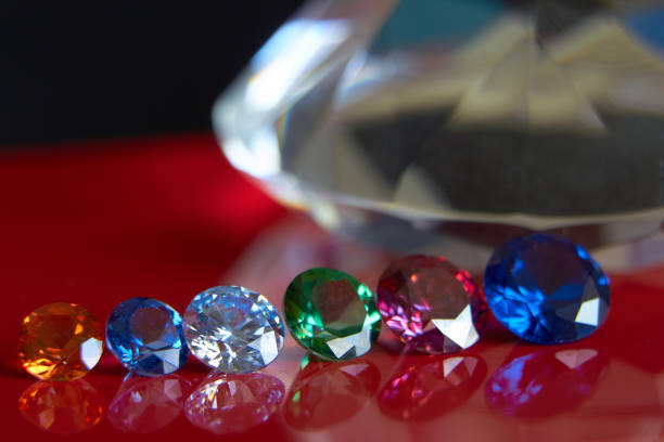 istock Huge diamond and several chic crystals on a red and black surface, shimmer and sparkle 1165920020