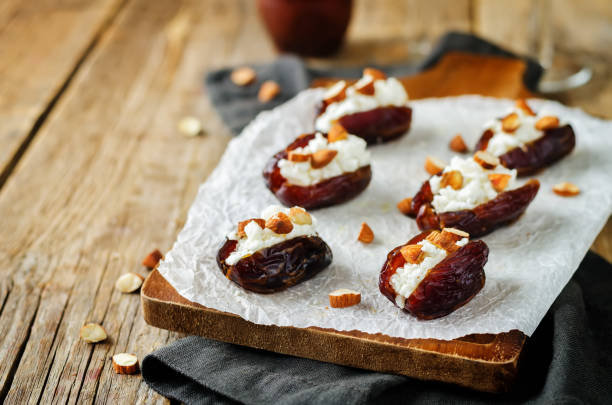 mandel- und ziegenkäse gefüllte datteln mit gläsern wein - stuffed stock-fotos und bilder