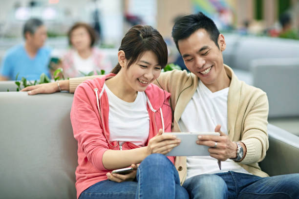 istock Asian Couple Reading Social Media Before Flight Departs 1165925144