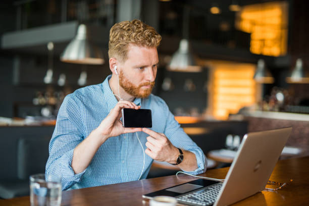 istock Young businessman showing content on a phone to a client online. 1165925904