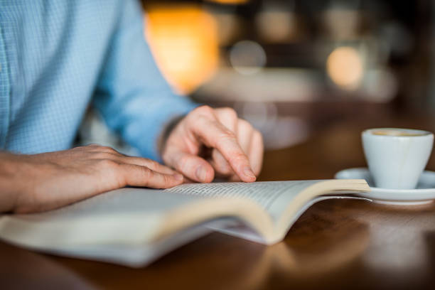 istock Unrecognizable young man reading a book hand close up. 1165925906