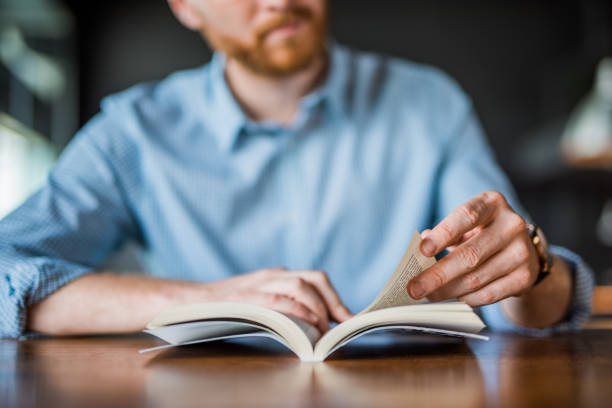 joven leyendo una mano de libro de cerca. - reading a book fotografías e imágenes de stock