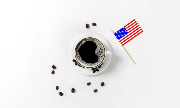 Photo of cup of coffee with coffee beans, saucer, spoon and american flag as a simbol of national coffee day, isolated on a white background, 3d render